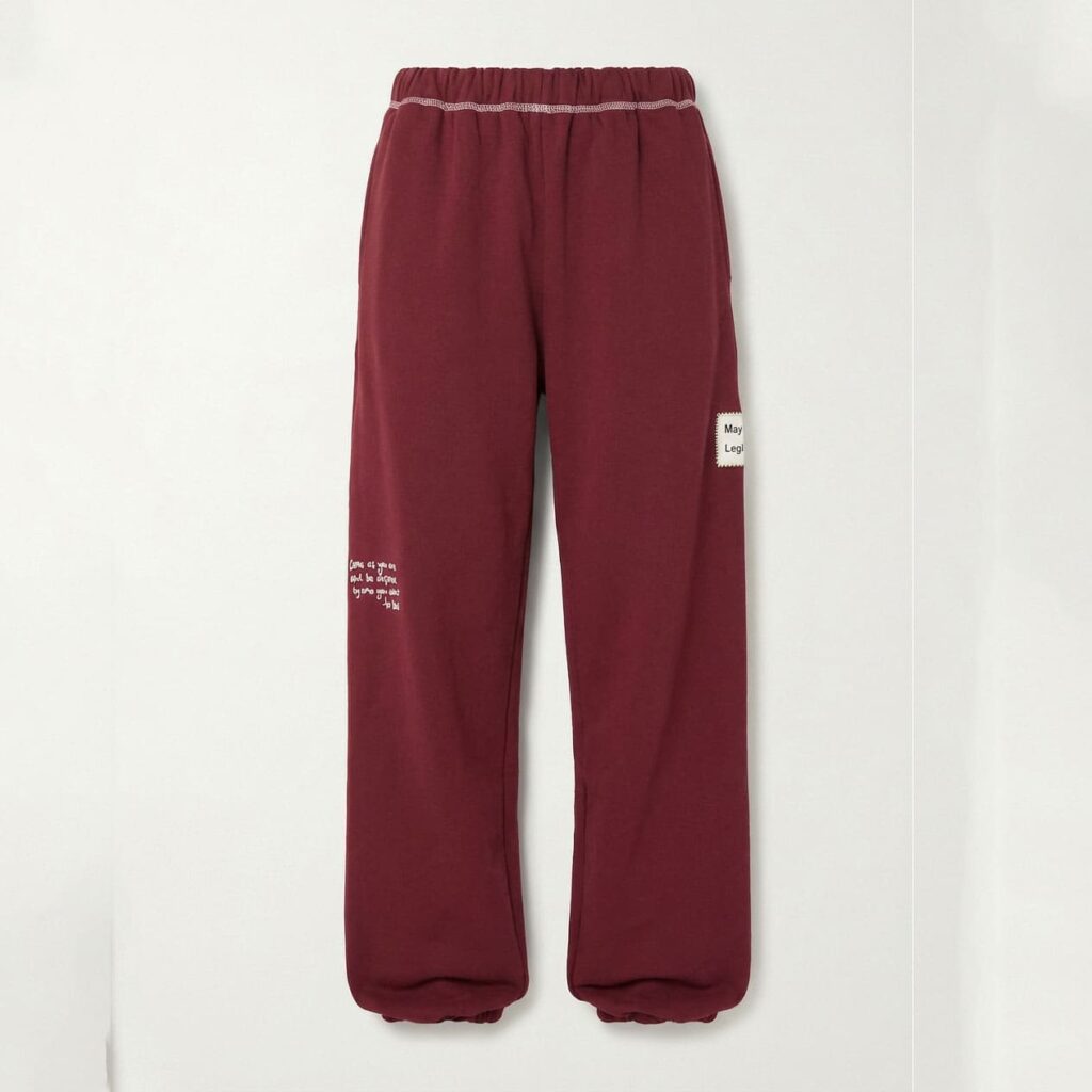 Burgundy cotton blend sweatpants with contrast stitching on the waistband, side text print, and brand patch, front view flat lay
