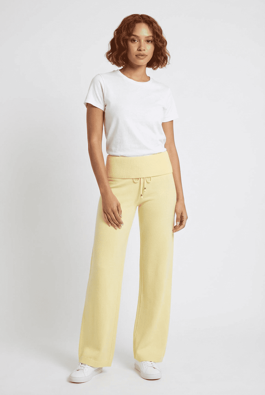 Model wearing butter yellow knit wide-leg trousers, front view paired with a white crewneck tee and white sneakers