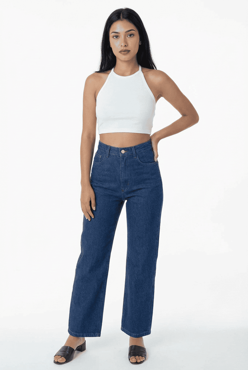 Model wearing white halter-neck cropped top, front view styled with dark blue high-waisted wide-leg jeans and black slide sandals