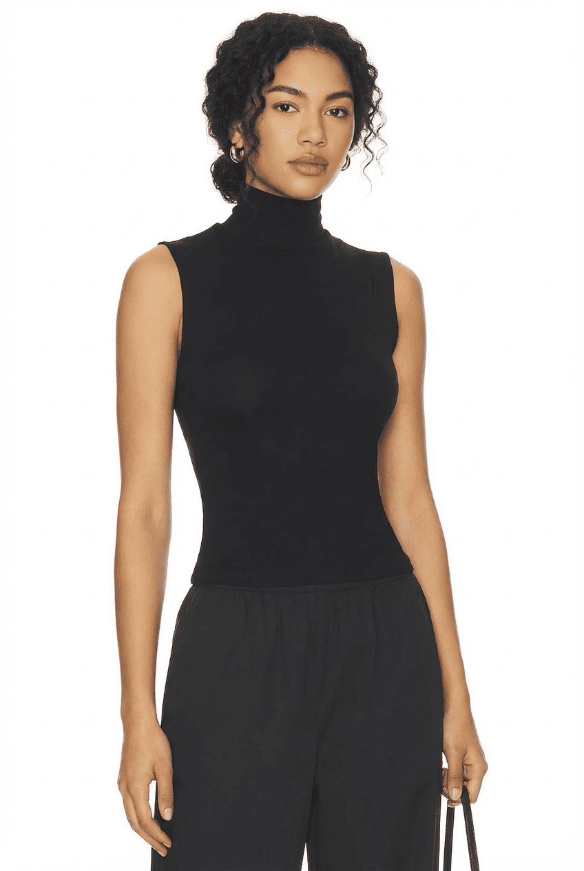Model wearing black slim-fit sleeveless turtleneck top, front view with black wide-leg trousers