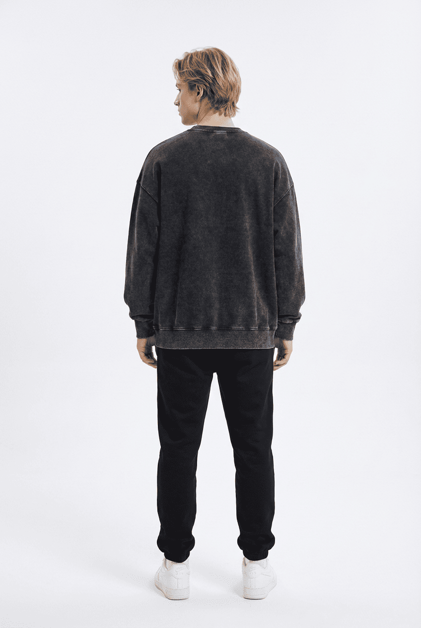 Model wearing black washed vintage oversized crewneck sweatshirt, back view with black pants and white sneakers