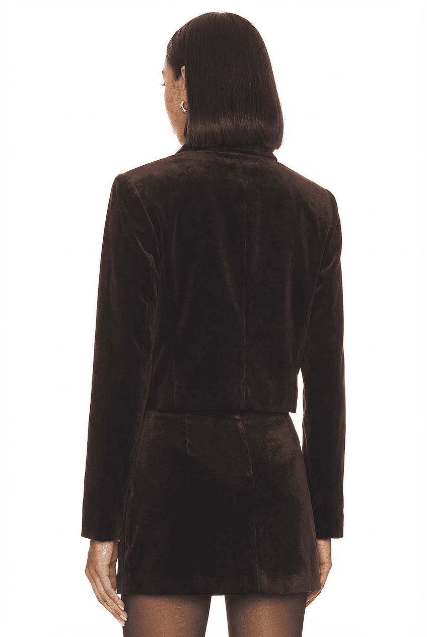 Model wearing dark brown velvet cropped jacket and matching mini skirt, back view