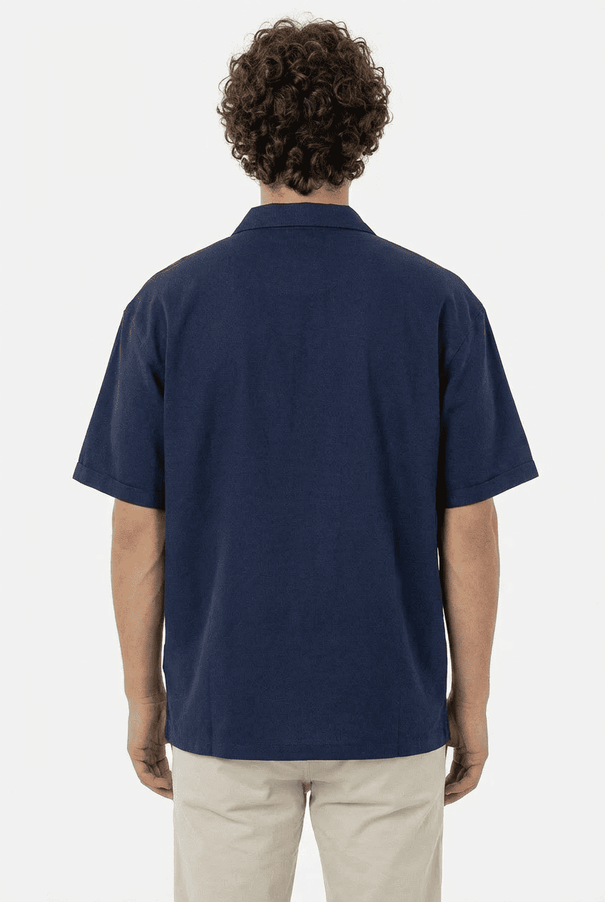Back view of model in navy blue half-zip short-sleeve polo shirt
