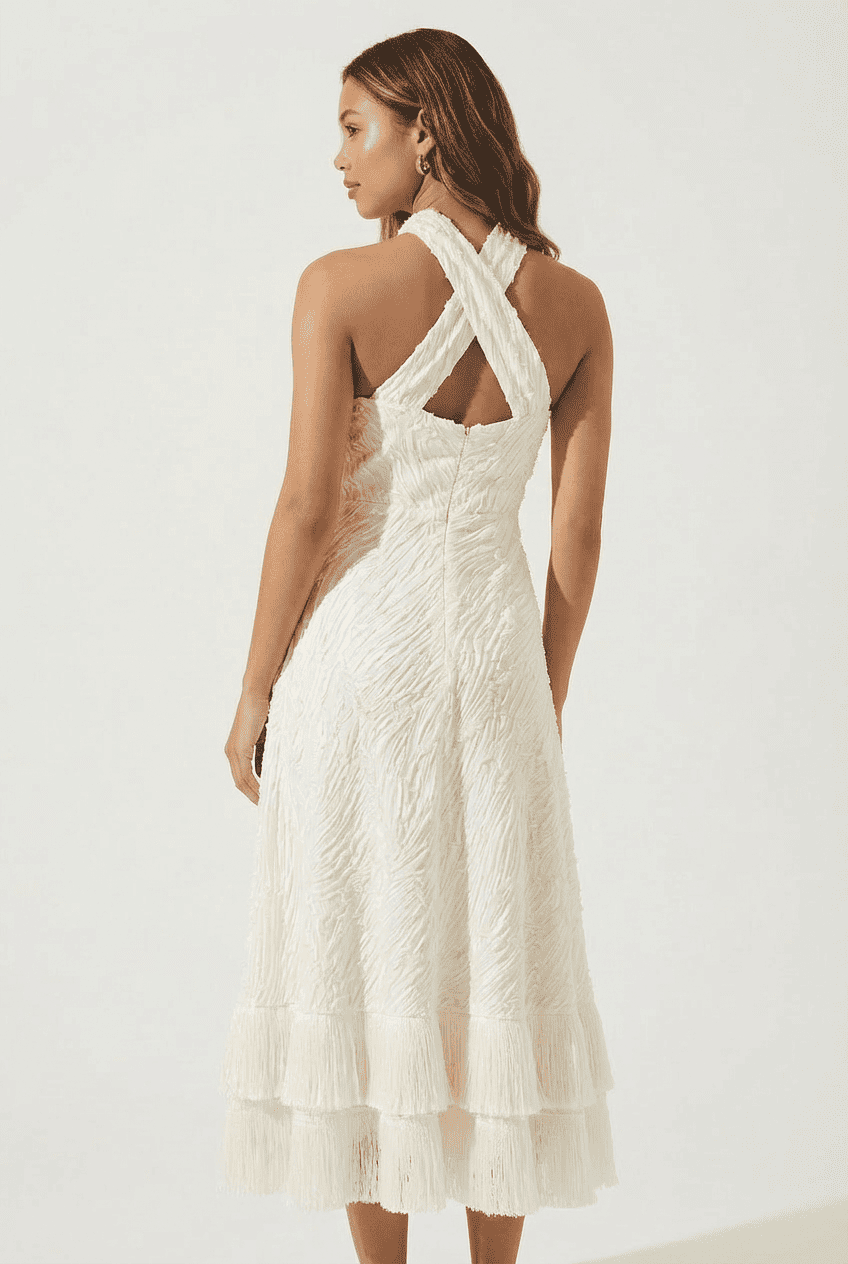 Model wearing ivory textured crinkle halter midi dress, back view showing cross-back design and full-length textured fabric