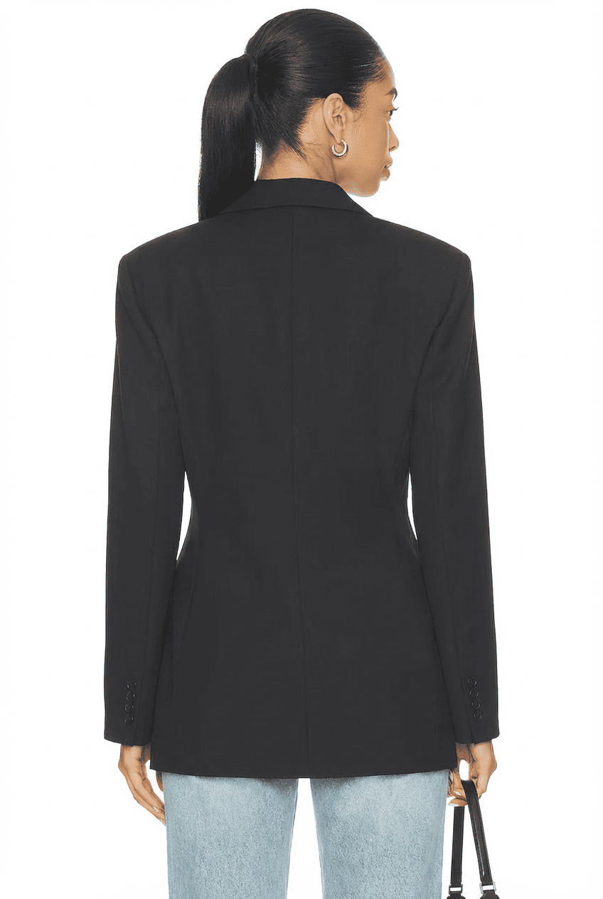 Model wearing black waist-cinched tailored blazer, back view showing clean back panel and buttoned cuffs, paired with light blue straight-leg jeans