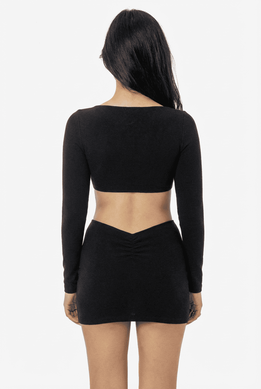 Model wearing black ribbed knit long-sleeve cropped top and mini skirt set, back view showing open-back top and V-cut skirt detail