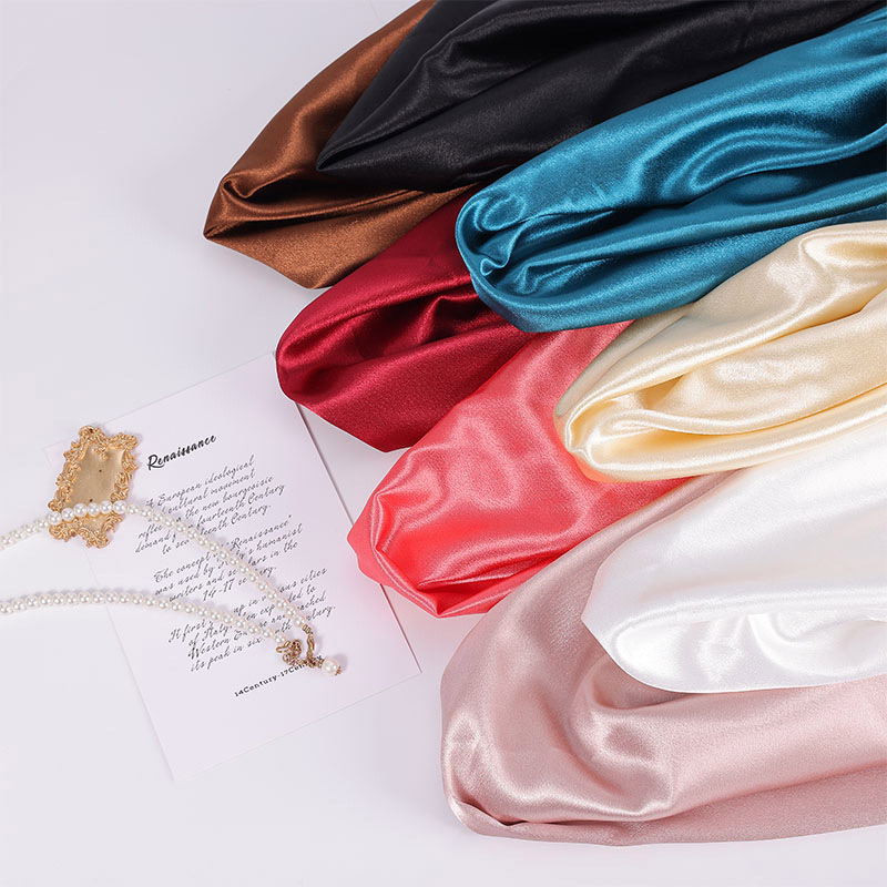 Layered thick satin fabric showing smooth glossy texture