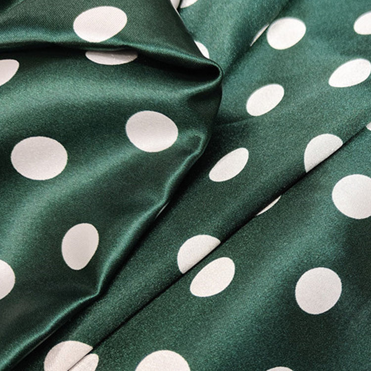 Green satin fabric with white polka dots